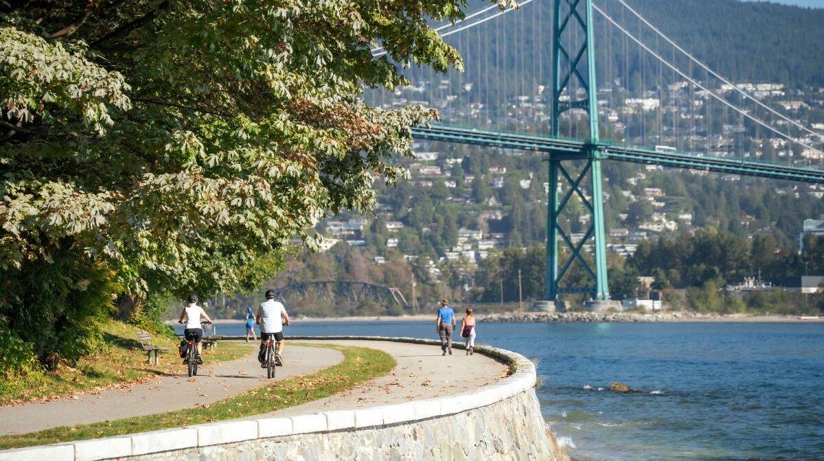 Cyclists on the Stanley Park Seawall near the Lions Gate Bridge in Vancouver